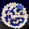 A tightly packed spray of blue and cream roses makes this graduation