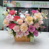 Roses in pink, peach, purple and cream arranged with airy accents in