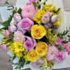 A vibrant, hand-tied bouquet blending soft romance with sunny energy. This arrangement