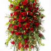 Vivid red roses and clustered red carnations form a dramatic, upright tribute