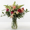 Soft pink roses and peach blooms mingle with creamy white alstroemeria and