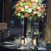 A tall, abundant centerpiece that reads like a sunlit garden-perfect for wedding