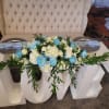 A lush, low centerpiece of white hydrangeas and roses punctuated with vibrant