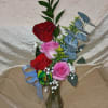 Red and pink roses mingle with touches of white and cool blue