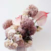 Pink and cream floral arrangement in a pale vase