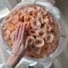 Large bouquet of peach roses wrapped in translucent paper