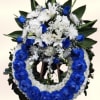 A large standing wreath built around vivid blue roses edged in white