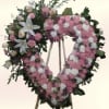 A soft pastel heart crafted for remembrance, this heart-shaped floral wreath is