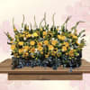 A luminous spray of yellow gerbera daisies and lilies designed for sympathy