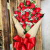 2 Dozen red roses wrapped in paper 
with greenery and baby breath