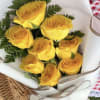 Bouquet of yellow roses wrapped in white paper