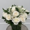 White roses and alstroemeria arranged in a green glass vase