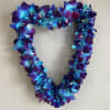 Heart-shaped floral wreath of blue and purple orchids on a wall