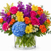 A bold and cheerful summer arrangement bursting with vibrant spray roses, fluffy