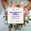 Handheld bouquet of pink and peach roses with greenery