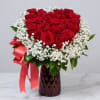 Red roses and white gypsophila in a red glass vase with a