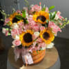 Bouquet of sunflowers, pink roses, and pink alstroemeria in an orange vase