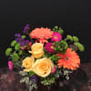 Bouquet of yellow roses, orange gerbera daisies, and purple accents