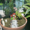 Miniature potted garden with a tiny house and pebble path
