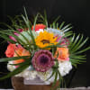 A bright sunflower center and coral-pink roses make this mixed-color bouquet a