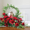 A dense cluster of red roses and red lilies gathered around a