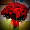 Bouquet of red roses in a glass vase with a red ribbon