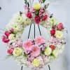 Floral wreath on a black stand with pink and white flowers