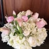 Pale pink roses and tulips nestled into a cloud of white hydrangeas
