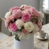A lush cluster of pink and white roses and hydrangeas creates an