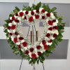 Heart-shaped wreath of red and white flowers on a stand