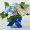 These ivory roses and sky&ndash;blue blooms will brighten anyone's day.