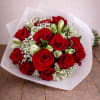 Bouquet of red roses with white filler flowers wrapped in white paper
