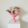 A dense, rounded cluster of soft pink roses greets the eye with