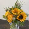 Yellow sunflower and rose bouquet in a glass vase with a striped ribbon