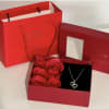 Red gift box with rose-shaped soap flowers and a heart necklace
