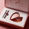 Pink gift box with a heart-shaped perfume bottle and lipstick
