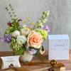 Mixed bouquet in a white vase with coffee and caramel gift items