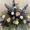 Tall floral arrangement with blue and peach blooms in a vase
