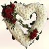 A large heart composed of dense white chrysanthemums creates a striking centerpiece