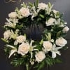 A simple and elegant sympathy wreath designed with fresh white blooms and