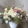 Hydrangeas, mums, roses, and other assorted flowers arranged together in an elegant