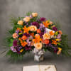 A vibrant gathering of lilies, roses, mums, and seasonal flowers arranged with