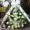 White funeral standing spray with ribbon and mixed flowers