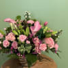 Pink roses and calla lilies arranged in a wicker basket