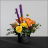 Summery arrangement in a black ceramic pot with a white lip. Liatris