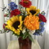 Sunflowers, red zinnias, blue tweedia and delphinium, and marigolds are gathered in