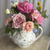 A floral teapot filled with corresponding flowers and subtle greenery. Perfect for