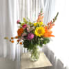 Sunflowers, peonies, snapdragons, and more are gathered in a vibrant composition. We