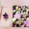 Pink gift box with a floral arrangement and matching boutonniere
