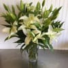 White lilies arranged in a clear glass vase